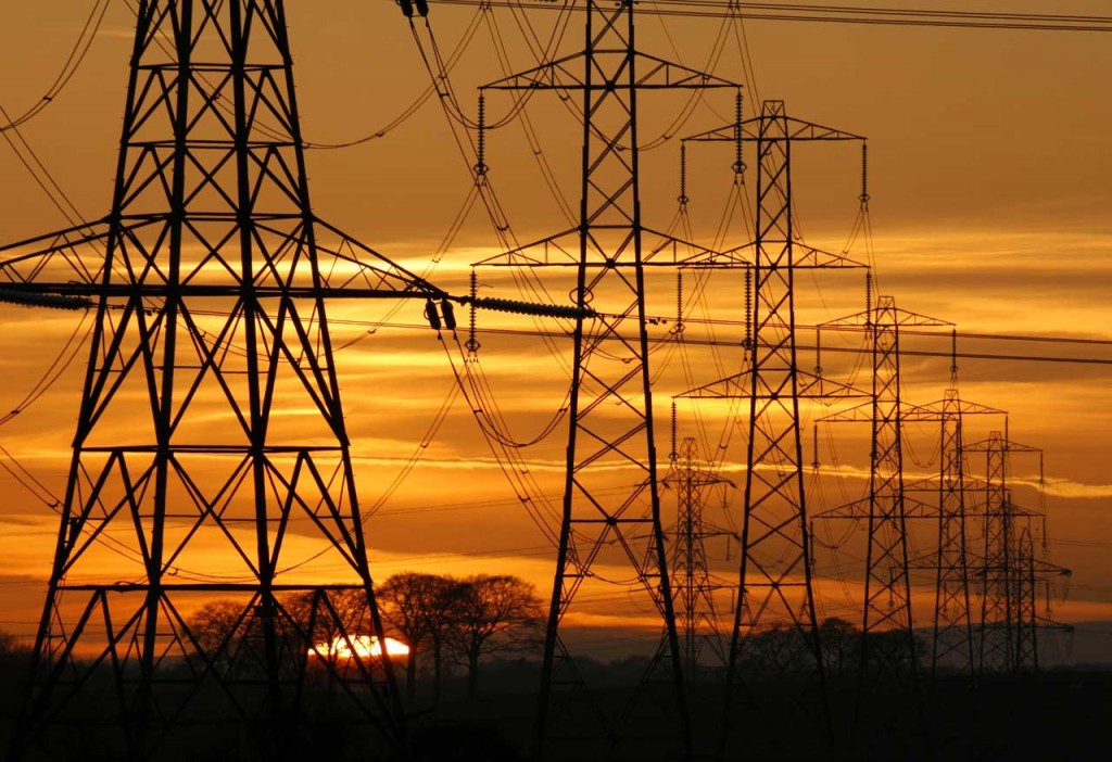 Sun setting behind a row of electricity pylons